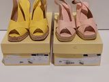 deux paires de chaussures jaunes et roses posées sur une boîte