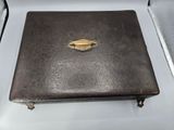 a brown leather case with a gold ring on it