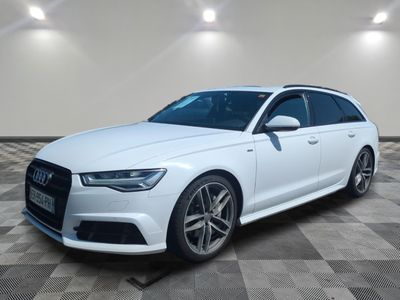 a white audi wagon parked in a large room with a checkered floor