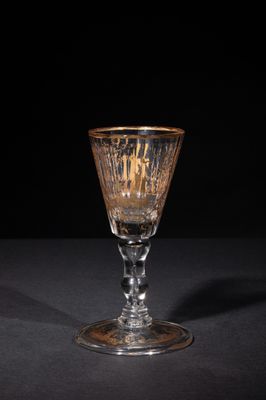 a close up of a wine glass on a table with a black background