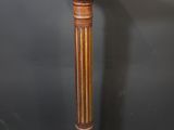 an antique wooden pedestal with a marble top on a grey background