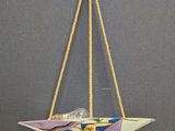 a close up of a paper boat hanging from a rope