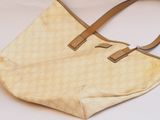 beige and brown handbag on white background with brown strap