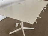 a white table with four chairs and a laptop on it