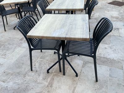 de nombreuses tables et chaises installées dehors, sur la terrasse