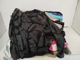une pile de vêtements posée sur une étagère blanche