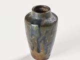 a small vase that is sitting on a white surface