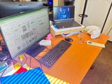 un bureau sur lequel se trouvent un ordinateur, un clavier, une souris et d'autres objets