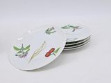 four plates with flowers and leaves on them on a white surface