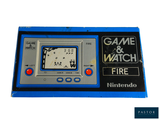 un Game & Watch exposé sur une surface blanche