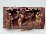 a red and gold plaque with a group of people in a boat