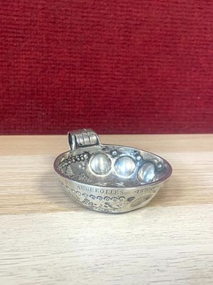 a silver bowl on a wooden table with a red background