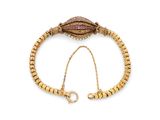 une image représentant un bracelet en or orné d'un coquillage