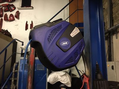 a blue suitcase sitting on top of a blue cart in a garage