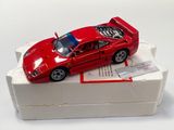 une petite voiture rouge posée sur une boîte blanche