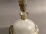une bouteille en verre d'où sort un bâton en bois