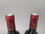 two bottles of wine sitting next to each other on a table