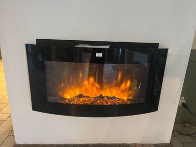 une cheminée avec un feu à l'intérieur, dans une pièce