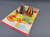 un livre ouvert sur lequel figurent l'image d'un bateau et celle d'un avion