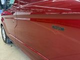 a close up of a red car with a sticker on it