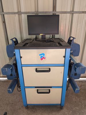a computer sitting on top of a cart in a garage