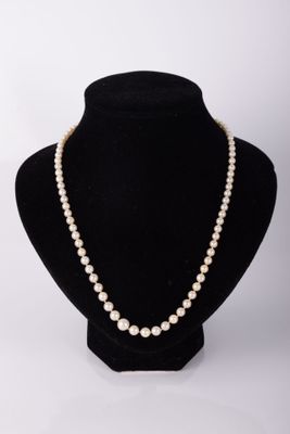 un collier de perles blanches sur un mannequin noir
