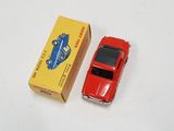 a red toy car next to a yellow box on a white surface