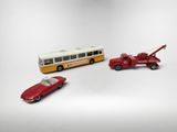trois petites voitures placées à côté d'un bus et d'une voiture