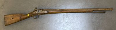 an old wooden rifle laying on top of a metal surface