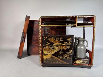 a black and gold box with a silver vase inside of it