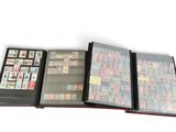 plusieurs types de timbres différents dans un classeur posé sur une surface blanche