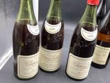 four bottles of wine are lined up on a counter