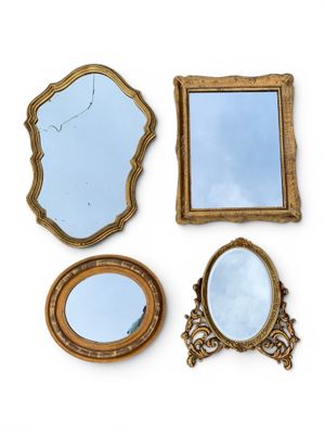 trois miroirs et un cadre de miroir posés sur une surface blanche