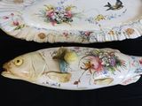 two decorative fish shaped dishes on a black table