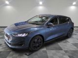 une voiture bleue est garée sur le sol à carreaux d'un garage