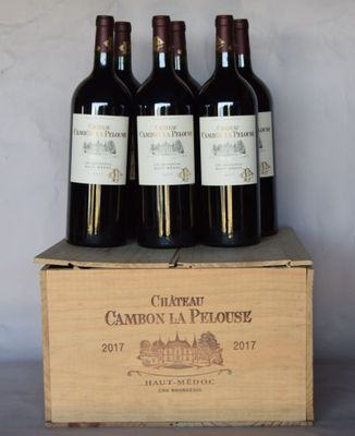 four bottles of red wine sit in a wooden box on a table