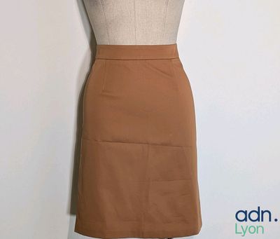 a mannequin with a brown skirt on a mannequin stand