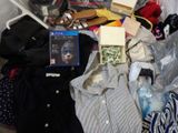a pile of clothing and other items on a bed