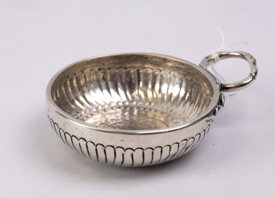 a silver bowl with a handle on a white surface
