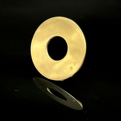 une bague en or sur une surface noire, avec un reflet