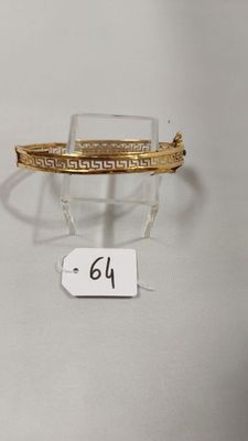 Gros plan sur un bracelet en or portant une étiquette