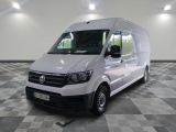 la camionnette blanche est garée dans une grande pièce au sol en damier