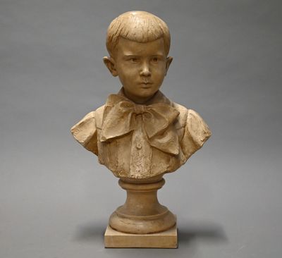 statue of a young boy with a bow tie on a pedestal