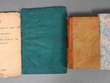 trois vieux livres sont alignés sur une table