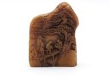 une image représentant un morceau de bois sculpté sur lequel figurent un crâne et un dragon