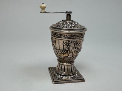 un vase en argent surmonté d'un oiseau