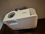 a white projector sitting on top of a wooden floor