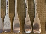 five spoons with different designs on them on a table