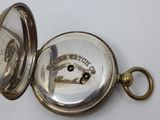 an old pocket watch with a key on a white surface