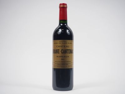 une bouteille de vin rouge posée sur une table blanche
